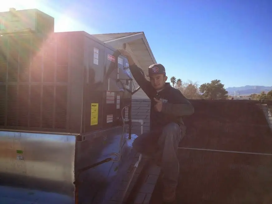 HVAC technician performing Heat Pump Repair on a rooftop unit in Waycross